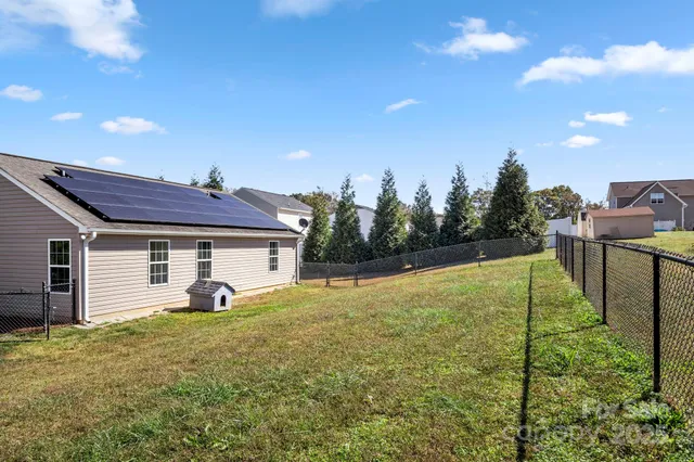 a view of a house with backyard and trees