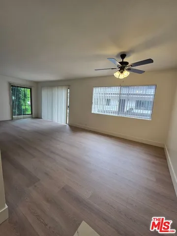 an empty room with a window and a ceiling fan