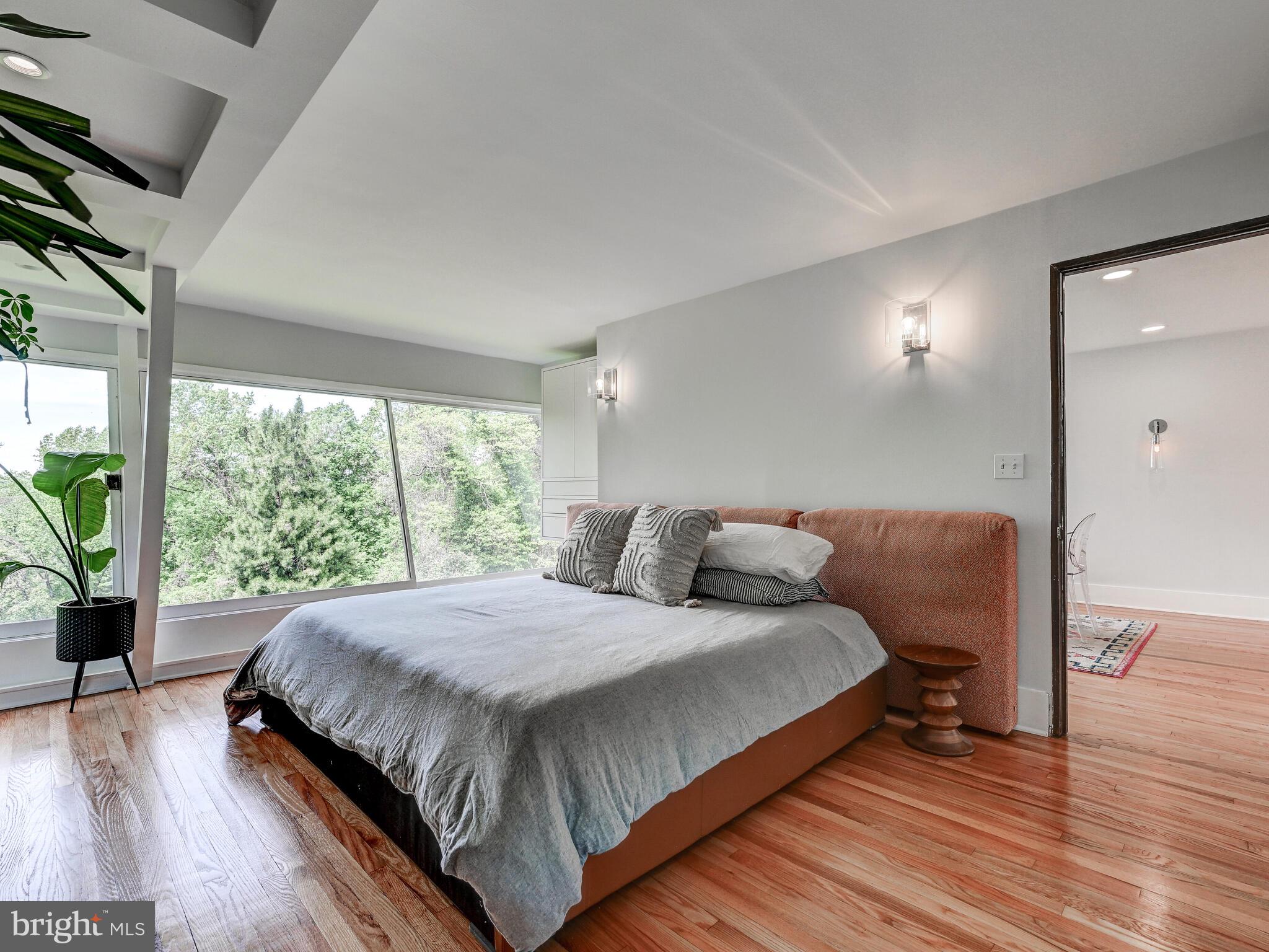 2025 Skyline Road Towson, MD 21204 - Photo 19 of 38 a bedroom with a bed lamp and a large window with wooden floor