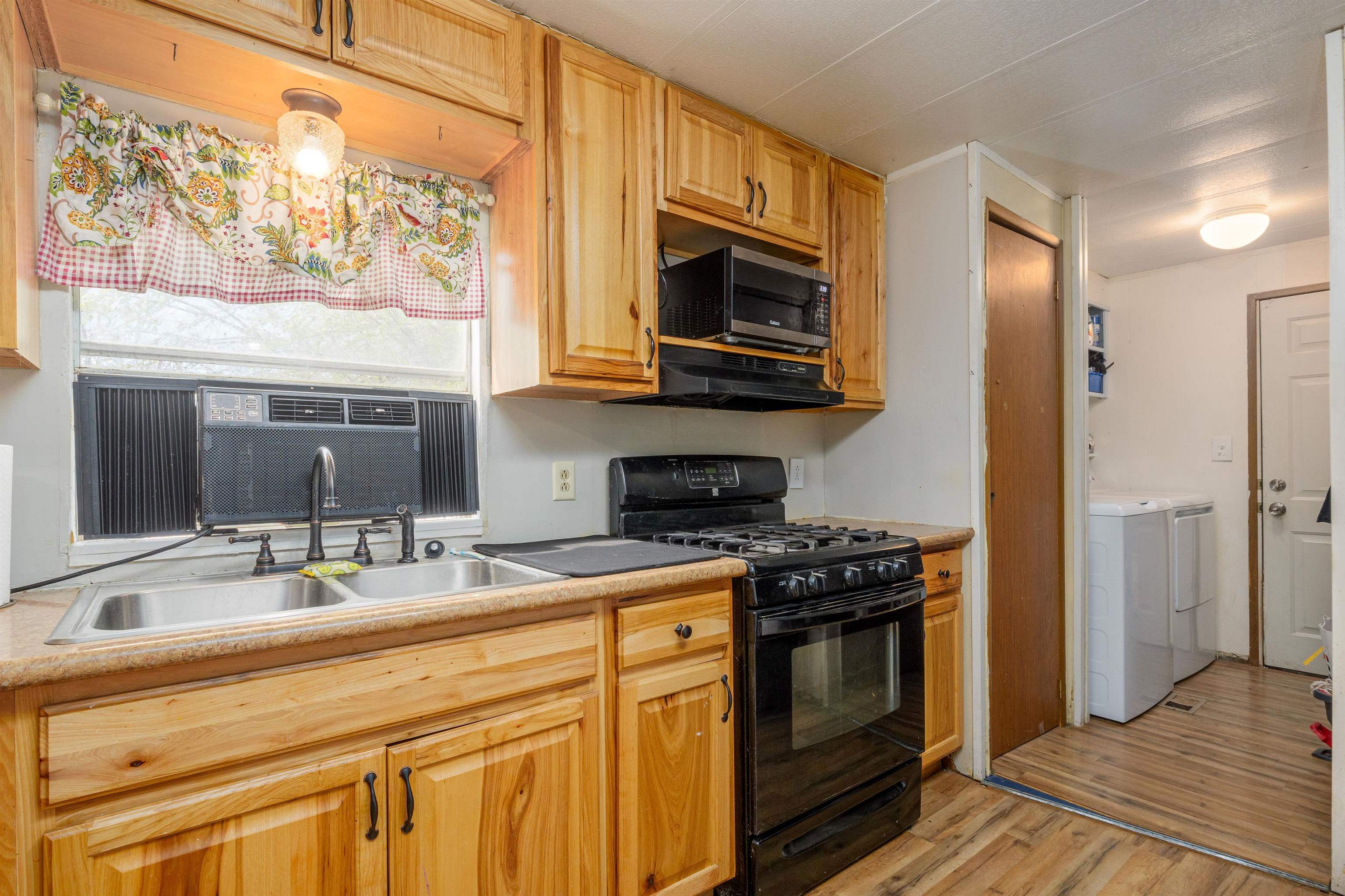 265 Southwest 11th Avenue Cedaredge, CO 81413 - Photo 11 of 39 a kitchen with stainless steel appliances a stove a sink and a microwave