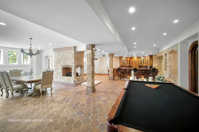 a view of a patio with couches table and chairs under an umbrella