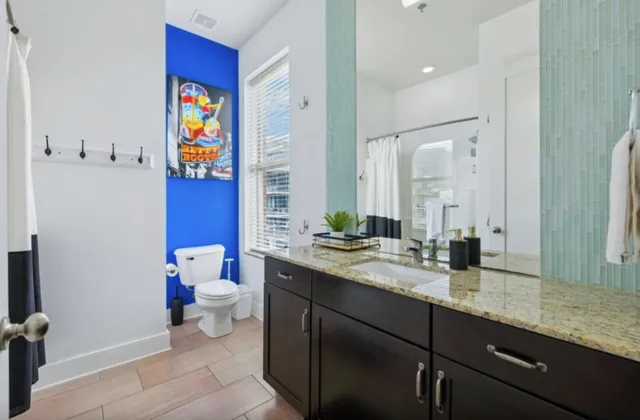 a bathroom with a granite countertop sink mirror and toilet