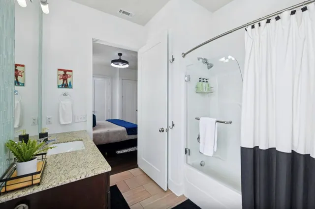 a bathroom with a tub shower and sink