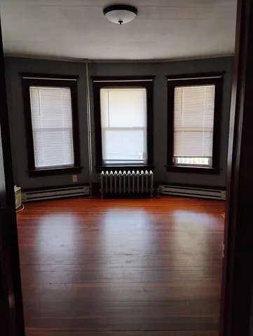 a view of a room with wooden floor and window