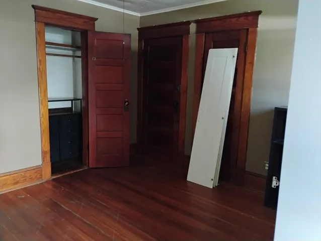 an empty room with wooden floor and closet