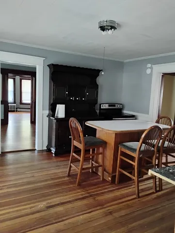 a dining room with furniture and wooden floor