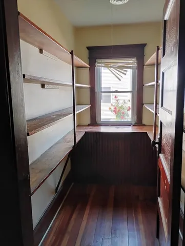 a view of walk in closet with wooden floor