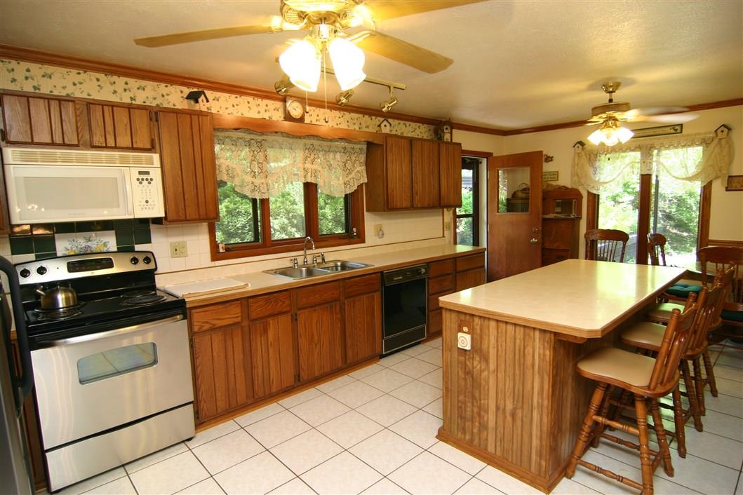 5969 Fitzgerald Road Rockford, IL 61102 - Photo 11 of 25 a kitchen with stainless steel appliances granite countertop a sink and a refrigerator