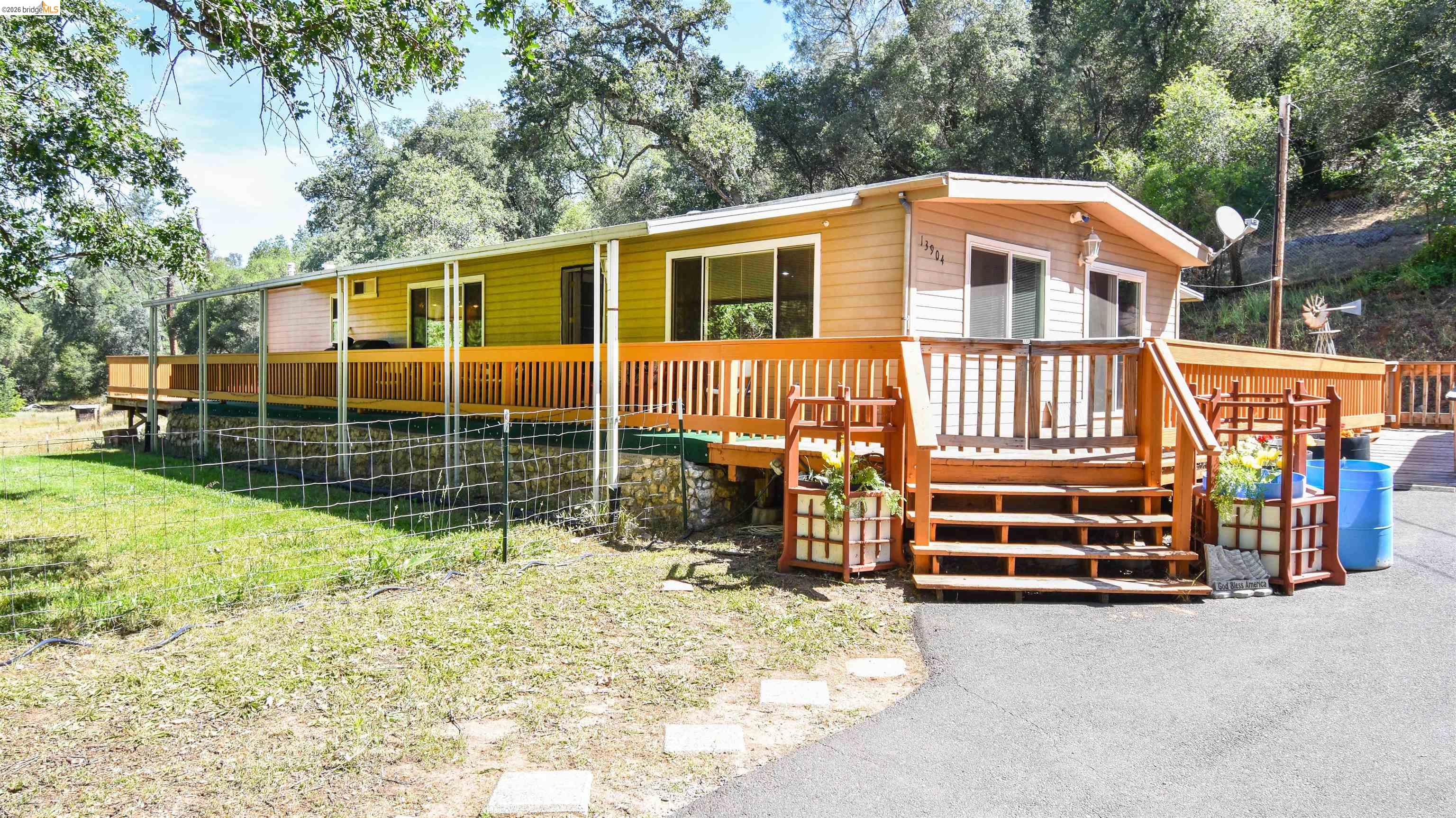 Exterior featuring horizontal siding, a full-length wood-finish deck with railing, and a wood-finish staircase entry