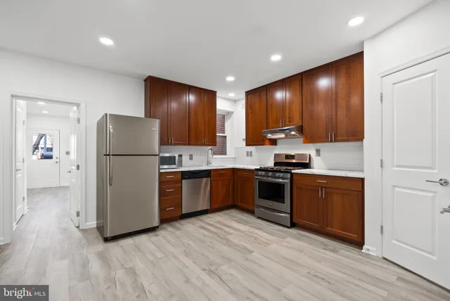 a large kitchen with a refrigerator and a stove top oven