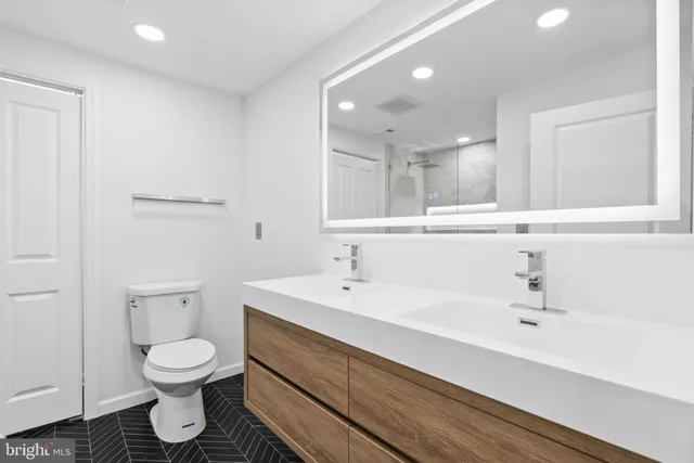 a bathroom with a toilet a sink and a mirror