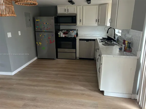 a kitchen with a refrigerator sink and cabinets