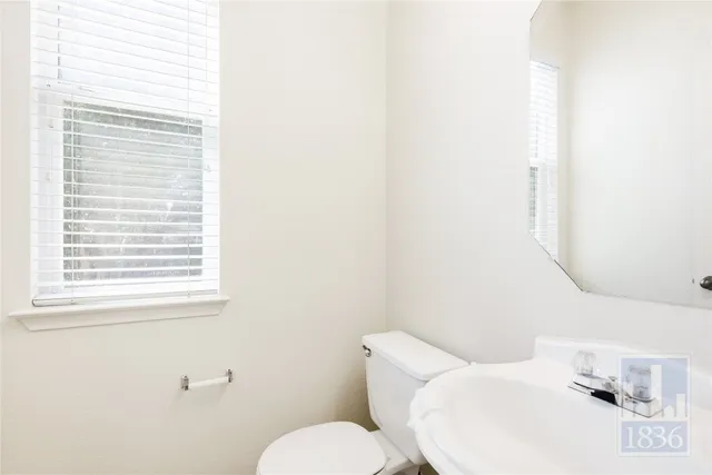 a white toilet sitting next to a bathroom sink