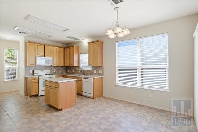 a open kitchen with a refrigerator a stove a sink and a window