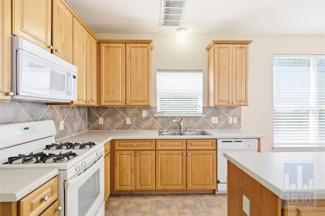 a kitchen with a sink stove top oven and cabinets