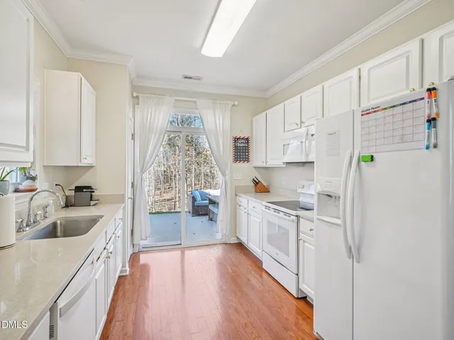 a kitchen with white cabinets and white appliances