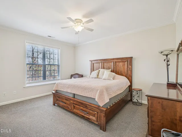 a spacious bedroom with a bed and a chandelier