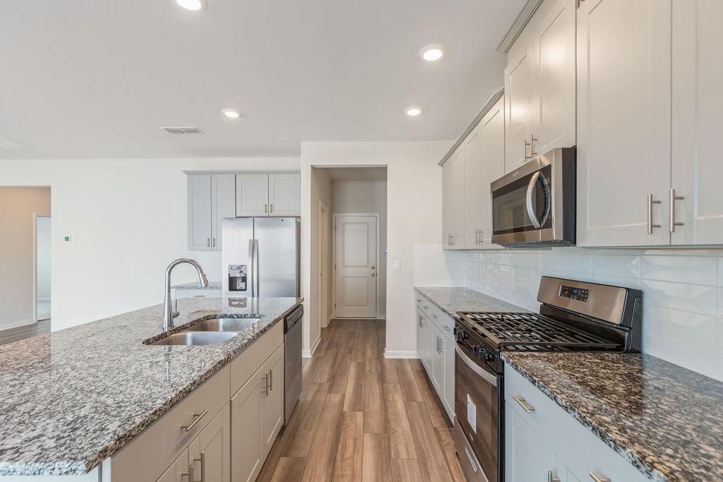 6901 Durham Lane Fairburn, GA 30213 - Photo 6 of 28 a kitchen with granite countertop a sink stainless steel appliances and cabinets