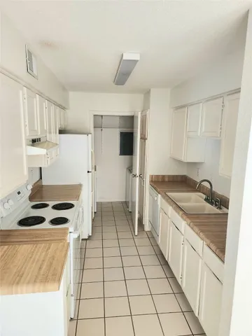 a kitchen with granite countertop a sink stove and cabinets