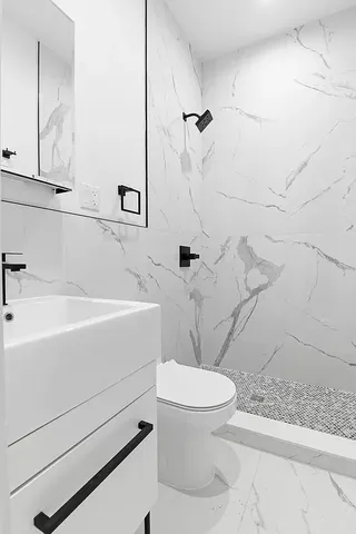 a bathroom with a sink a toilet and shower