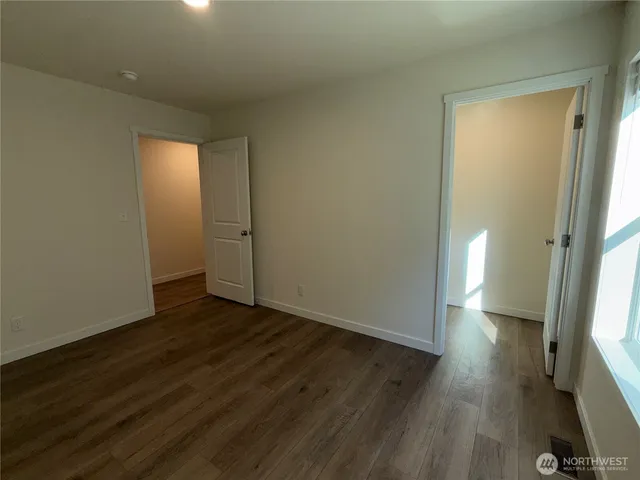 an empty room with wooden floor and a window