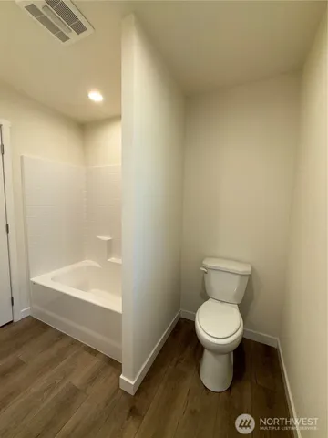 a white toilet sitting next to a bath tub