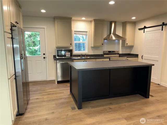 a kitchen with stainless steel appliances granite countertop a stove a sink and a refrigerator