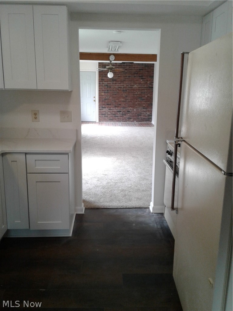 613 Jackson Street Amherst, OH 44001 - Photo 11 of 29 Corridor featuring light carpet, brick wall, and dark wood-style flooring