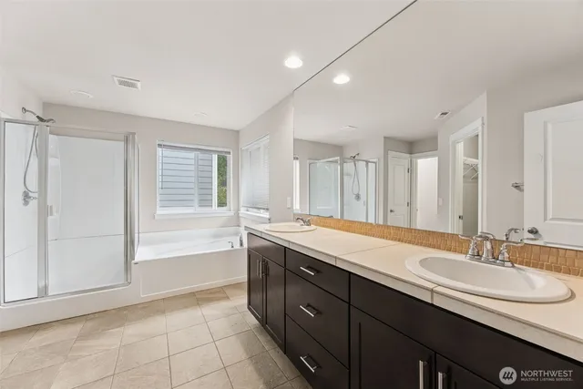 a spacious bathroom with a granite countertop sink a mirror and a bathtub