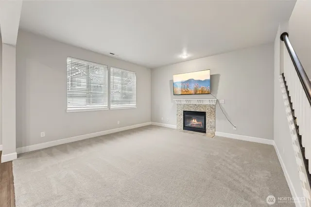 a view of an empty room with a window and fireplace