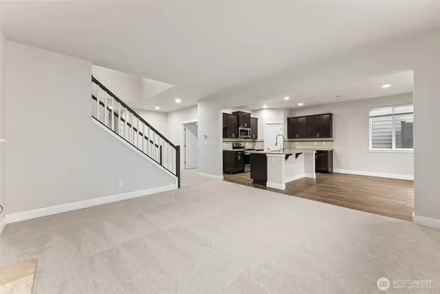 a view of a kitchen with a sink stove cabinets and stairs