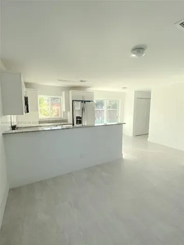 a view of a big room with kitchen and windows