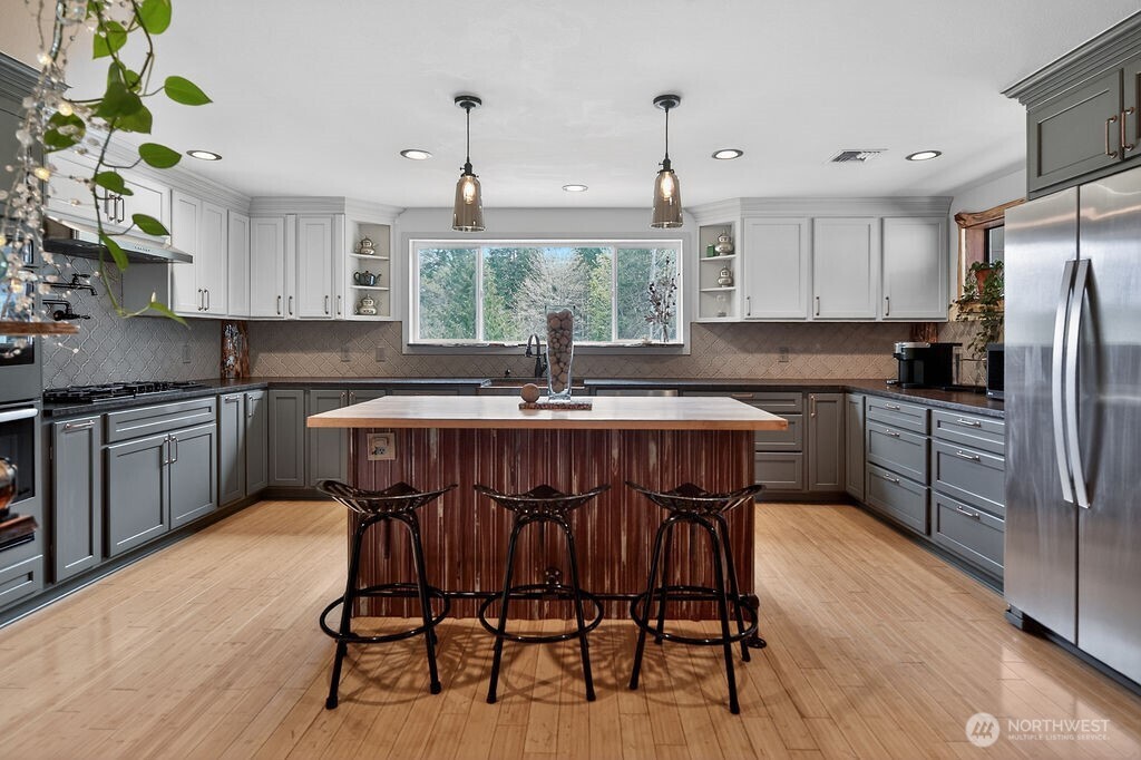 91 Goforth Road West Sequim, WA 98382 - Photo 12 of 40 a kitchen with granite countertop a table chairs stove and cabinets