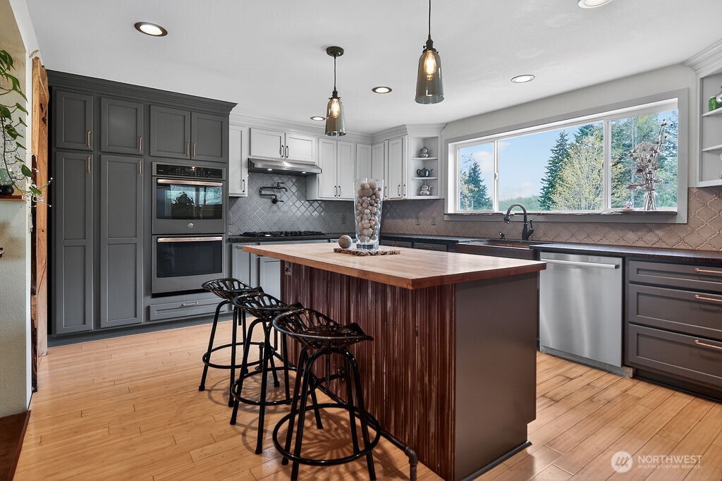 91 Goforth Road West Sequim, WA 98382 - Photo 13 of 40 a kitchen with stainless steel appliances a table and chairs in it