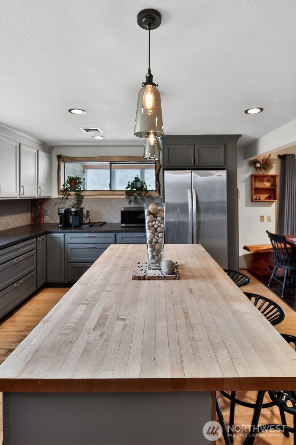 91 Goforth Road West Sequim, WA 98382 - Photo 20 of 40 a kitchen with stainless steel appliances kitchen island granite countertop a table chairs in it and wooden floors