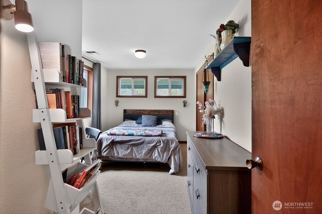 91 Goforth Road West Sequim, WA 98382 - Photo 22 of 40 a bedroom with a bed and a book shelf