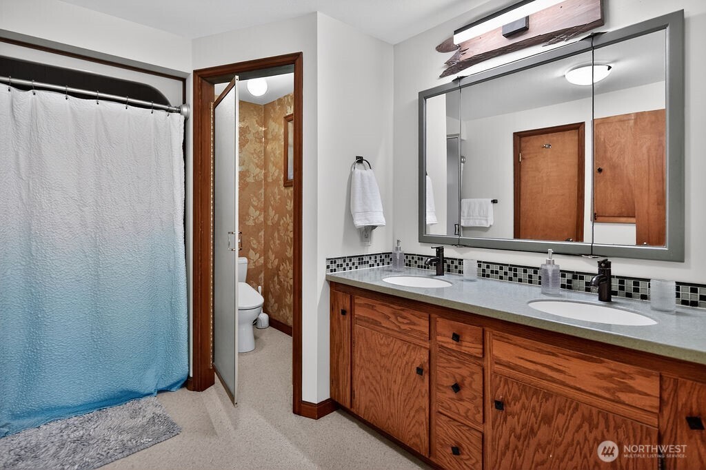 91 Goforth Road West Sequim, WA 98382 - Photo 28 of 40 a bathroom with a double vanity sink and mirror