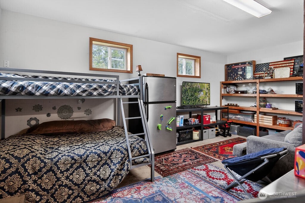 91 Goforth Road West Sequim, WA 98382 - Photo 29 of 40 a bed room with a bed and a book shelf