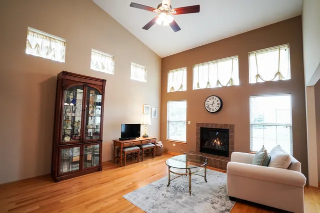 a living room with furniture a fireplace and a large window