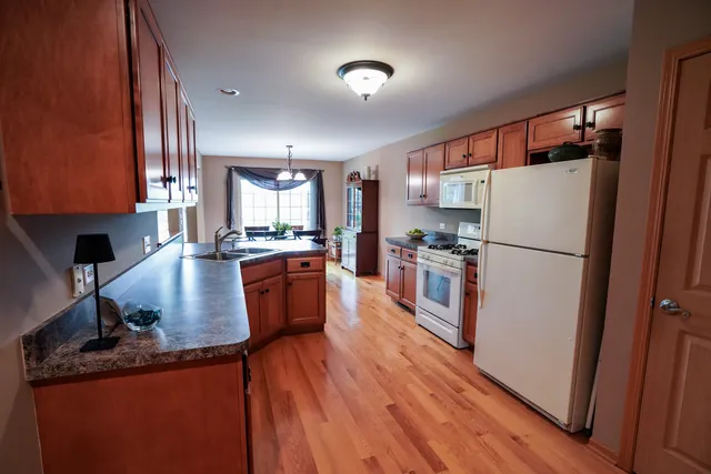 a kitchen with granite countertop stainless steel appliances a refrigerator a stove top oven and a sink