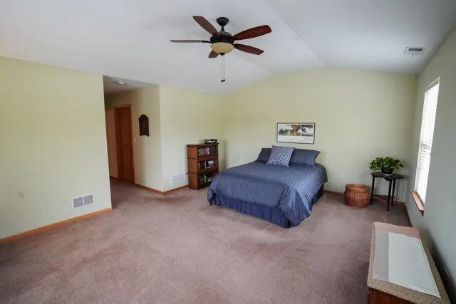 a spacious bedroom with a bed and a chandelier