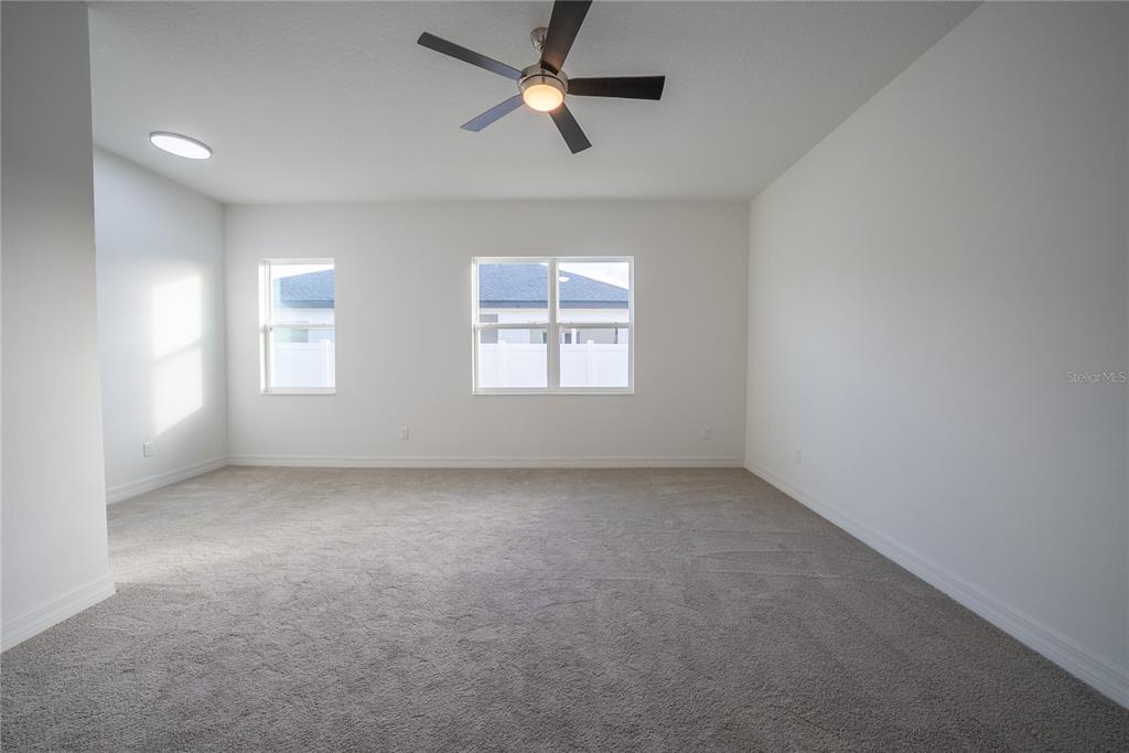 4720 Southeast 25th Street Ocala, FL 34480 - Photo 11 of 27 en empty room with windows and ceiling fan