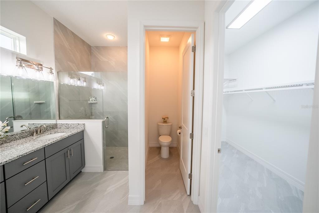 4720 Southeast 25th Street Ocala, FL 34480 - Photo 12 of 27 a bathroom with a granite countertop sink a toilet and shower