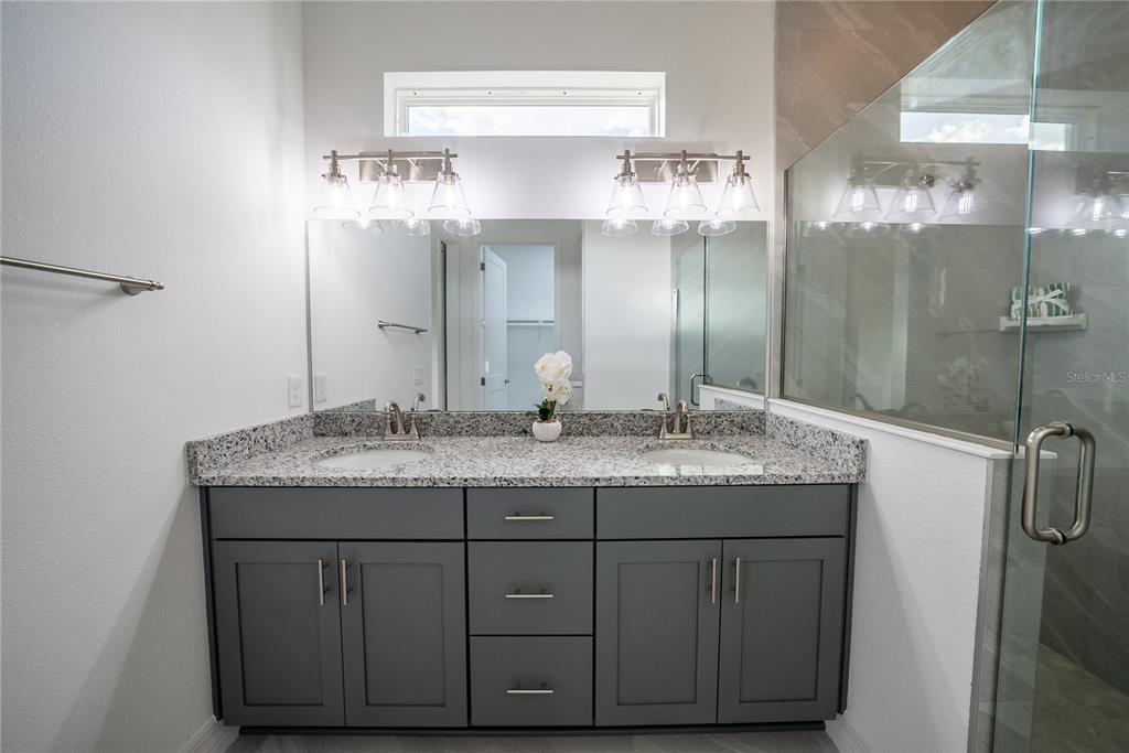 4720 Southeast 25th Street Ocala, FL 34480 - Photo 13 of 27 a bathroom with a granite countertop sink a large mirror and a shower