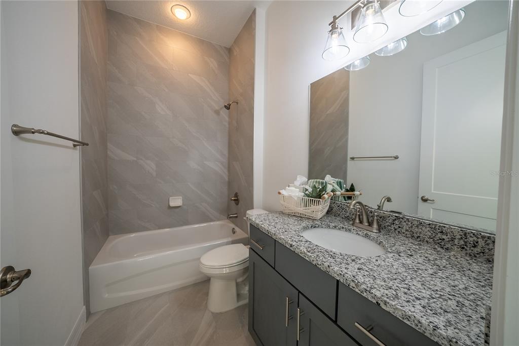 4720 Southeast 25th Street Ocala, FL 34480 - Photo 22 of 27 a bathroom with a granite countertop bathtub a sink and mirror
