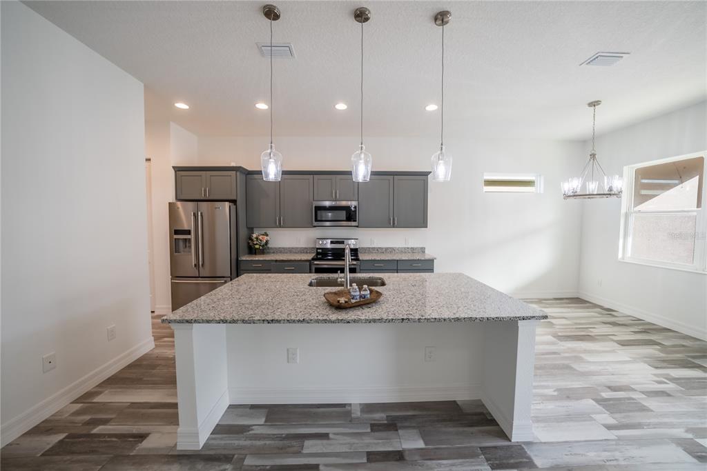 4720 Southeast 25th Street Ocala, FL 34480 - Photo 5 of 27 a kitchen with kitchen island a counter top and stainless steel appliances