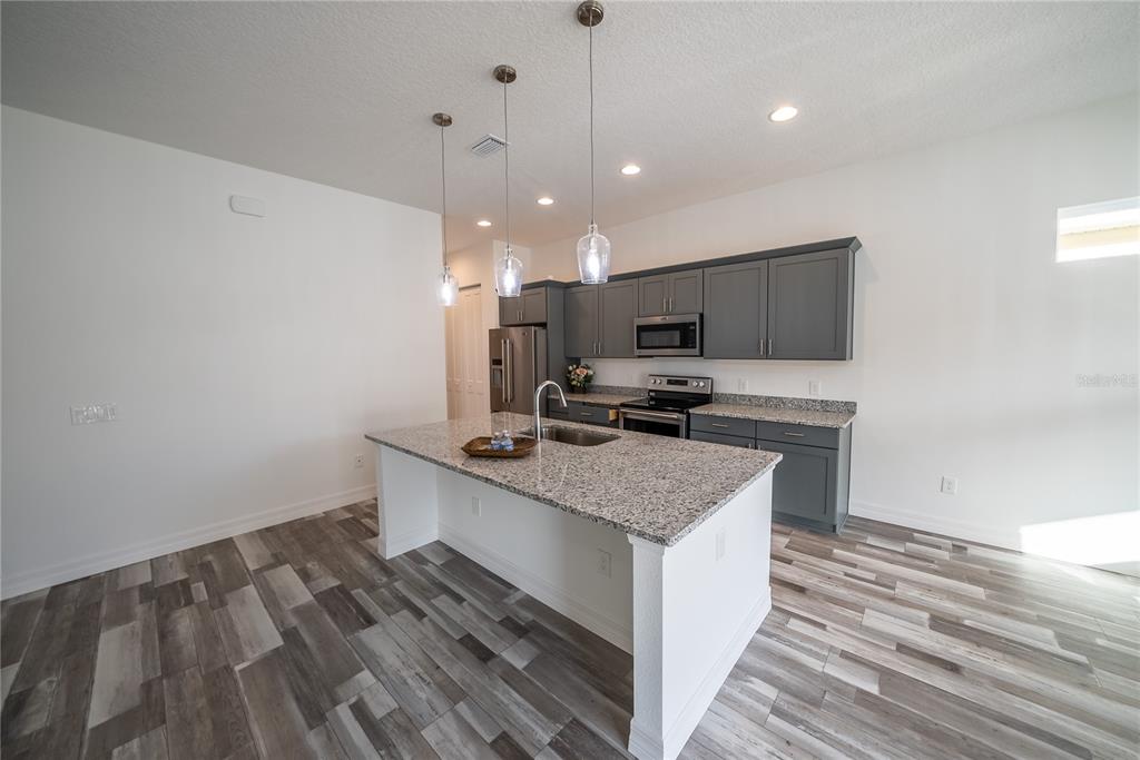 4720 Southeast 25th Street Ocala, FL 34480 - Photo 6 of 27 a kitchen with a sink stove and microwave