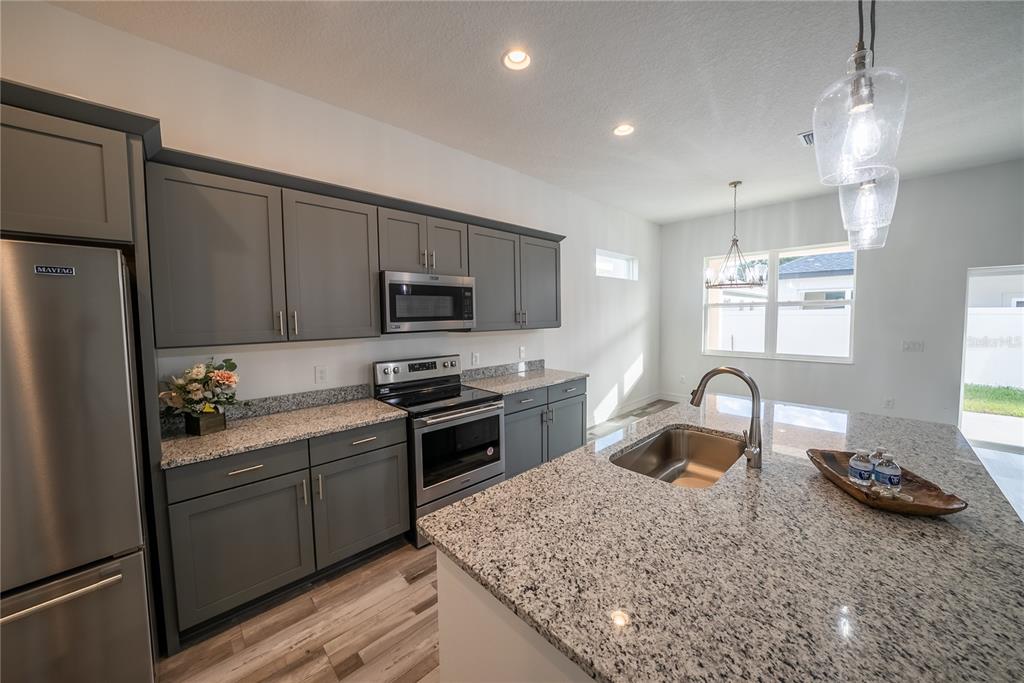 4720 Southeast 25th Street Ocala, FL 34480 - Photo 7 of 27 a kitchen with a sink a stove and refrigerator