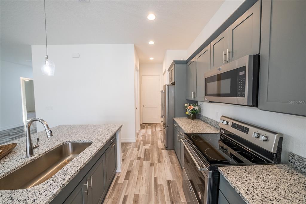 4720 Southeast 25th Street Ocala, FL 34480 - Photo 8 of 27 a kitchen with stainless steel appliances granite countertop a sink stove and refrigerator