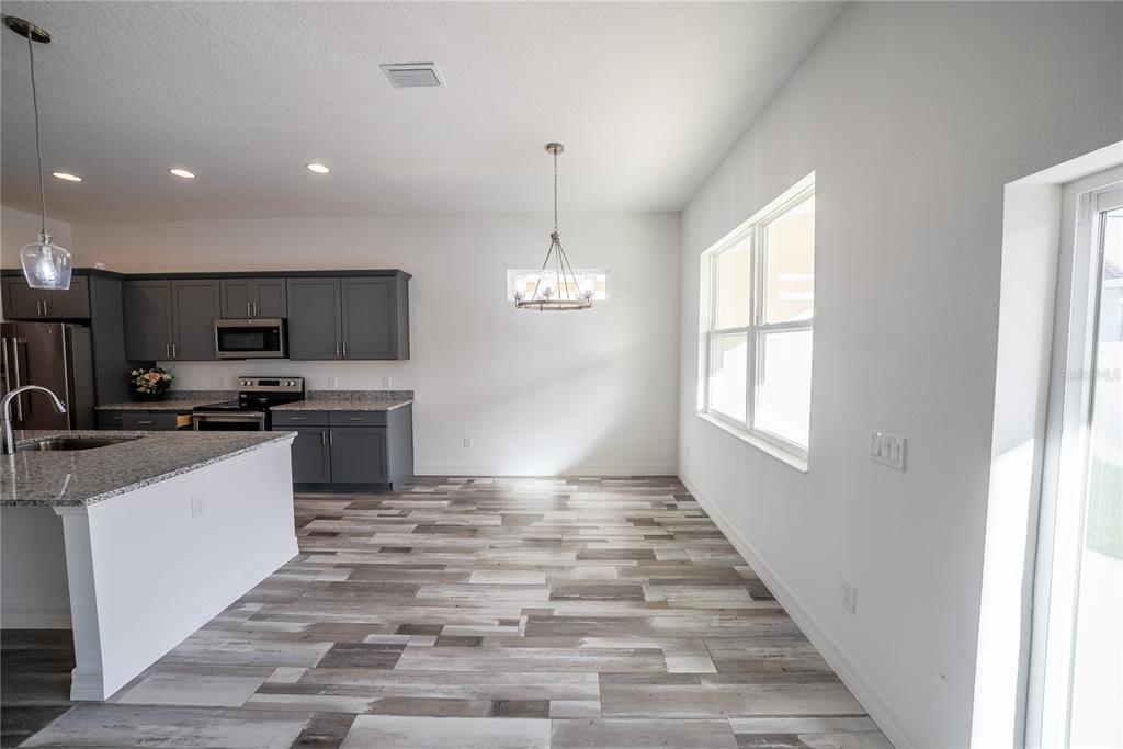 4720 Southeast 25th Street Ocala, FL 34480 - Photo 9 of 27 a kitchen with granite countertop a stove top oven and cabinets
